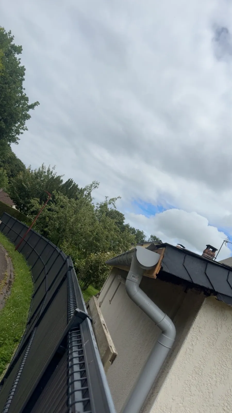 Descente d’eaux pluviales en zinc posée sur un pignon